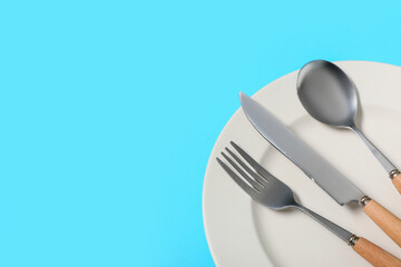 Beautiful table setting with silver cutlery on blue background, closeup