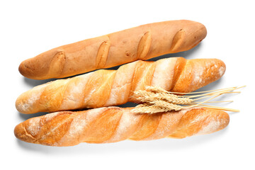 Fresh baguettes and wheat on white background