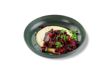 Tender braised beef served with a rich berry sauce and creamy mashed potatoes, garnished with fresh microgreens on a stylish green ceramic plate