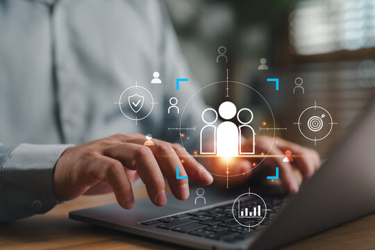 Hands typing on laptop with customer targeting icons, representing audience segmentation, digital marketing, CRM strategy, data analytics, personalization, and customer engagement in business.