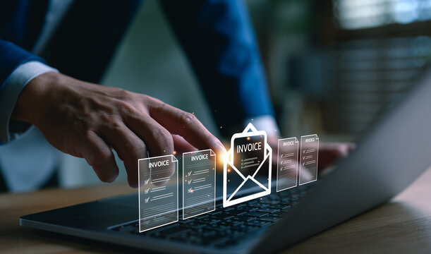Businessman using laptop with digital invoice icons, representing e-invoicing, billing automation, financial technology, online payment, accounting software, ERP system, and paperless finance process.