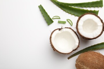 Hair treatment. Coconuts and aloe leaves on white background, flat lay. Space for text