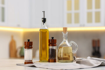 Bottles of salad dressings, salt and pepper on white table in kitchen