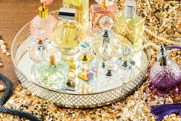 Different luxury perfumes and accessories on wooden table
