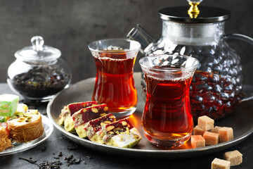 Tasty Turkish tea and delight on black table