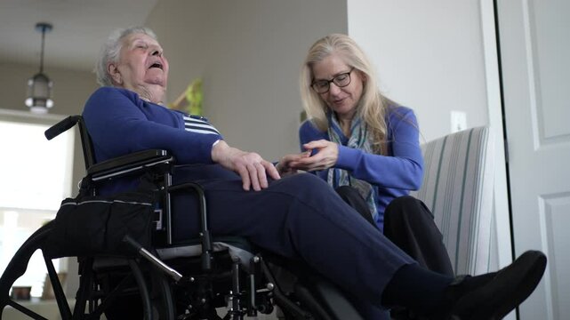 An elderly woman in a wheelchair enjoys a warm visit with her daughter. They share moments of care and love in the comfort of their cozy home environment.