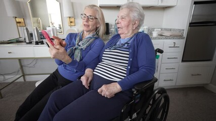 A loving daughter video chats with her elderly mother in a cozy indoor setting, capturing precious family memories and moments of togetherness.