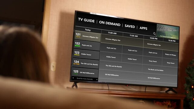 Woman watches a generic channel tv guide in her home