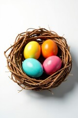 Obraz premium Colorful Easter eggs nestled in a straw-lined bird's nest, white background, easter eggs, background