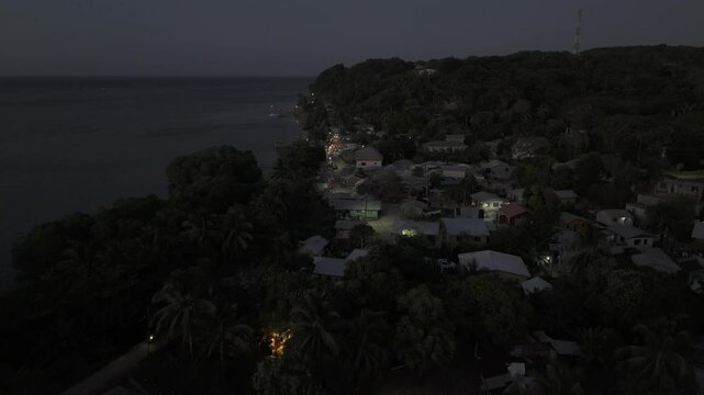 Drone flies north along Punta Gorda in Roat&aacute;n, Honduras just after sunset