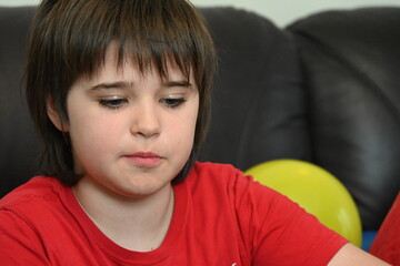 child blowing up balloons for birthday