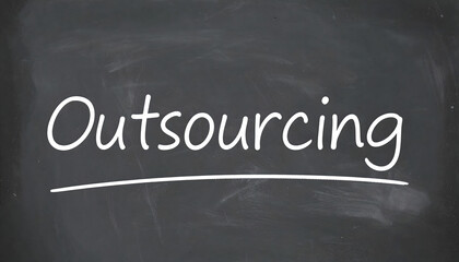 Fototapeta premium Outsourcing written on a chalkboard in white chalk with underline graphic.