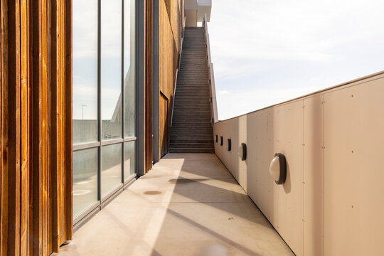 Long corridor with modern wood paneling and clean geometry in Copenhagen. Urban housing design with elegant lighting and strong perspective.