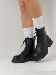 Fashionable black combat boots paired with stylish white socks in a modern studio setting