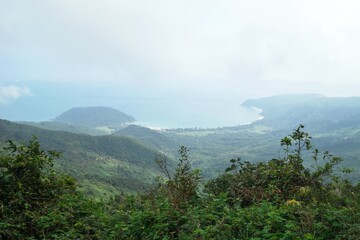 Picturesque mountain landscape with green hills and a tranquil bay in the distance. Prao, Vietnam.