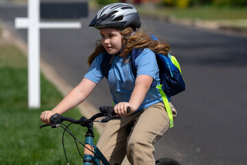 Child bike ride. Teen boy biking down summer road. Kid riding bicycle with smile. Child cycling....
