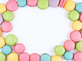 Elegant dessert scene featuring colorful macarons on a porcelain plate, artistic overhead composition, natural light from the side, variety of flavors represented by vibrant colors—raspberry, pistachi