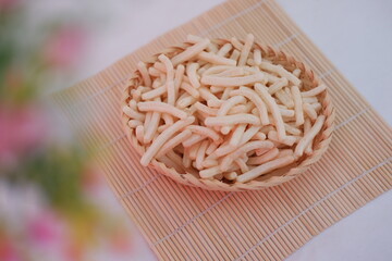 a woven basket filled with long, thin, white puffed snacks