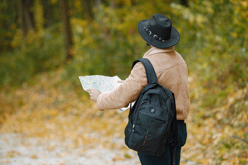 Black man standing on a road and looking at map