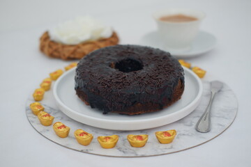 round chocolate donut covered in rich chocolate glaze and topped with chocolate sprinkles
