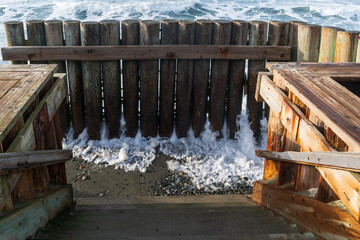 Tide rolls in at the base of the beach stairs in Libbey Beach Park, Whidbey Island, WA.