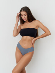 Obraz premium Stunning female model showcasing modern fashion in a sleek studio setting with elegance