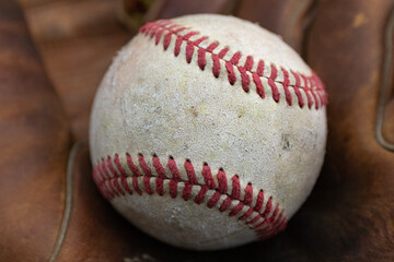Closeup of a baseball in old mitt. I used a macro lens to bring out the textures. Vintage and rustic to emphasize the love for America's national pastime.