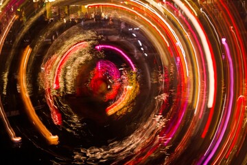 Long exposure of a colorful illuminated Ferris wheel at an amusement park.