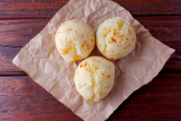 homemade cheese bread, traditional Brazilian snack, on the breakfast table in a rustic farm kitchen