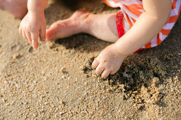 Child Playing in Sand on Beach at Summer Day