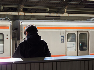名古屋駅のホームで電車待ちの若い男性の姿
