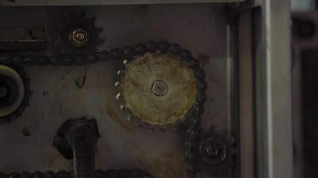 Engranaje en movimiento, cadena de engranajes industriales en acci&oacute;n, maquinaria mec&aacute;nica, proceso de fabricaci&oacute;n y tecnolog&iacute;a antigua. Sistema de engranajes en funcionamiento, maquinaria vintage. 