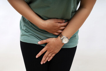 Pretty Asian woman holds crotch with hands, wants to urinate. Concept of urinary incontinence,...