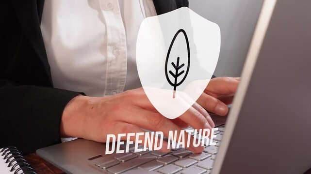 Primer plano de las manos de una mujer trabajando en un teclado de computadora con un &iacute;cono de escudo que contiene una hoja, debajo del cual est&aacute; la frase "Defiende la Naturaleza".