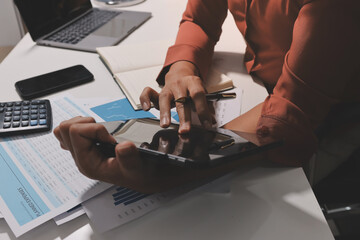 Working from home, Closeup business woman using laptop computer and analyzing financial report.