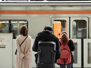 名古屋駅のホームで電車待ち若い男女たちの姿