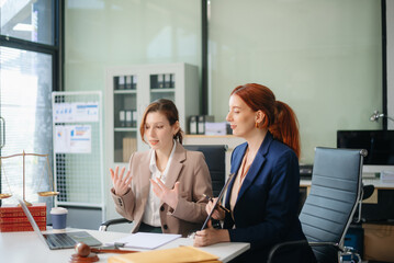 Professional female lawyers consulting on legal cases in a modern office. Perfect for law, business, justice