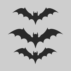 Three spooky bat silhouettes perfect for Halloween decorations simple dark grey bats on light grey background vector