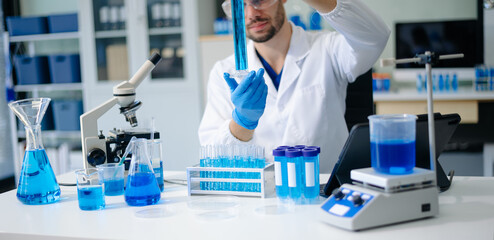 male scientist working with micro pipettes analyzing biochemical samples, advanced science chemical...