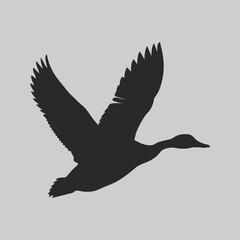Obraz premium Elegant black silhouette of a graceful goose in flight against a light gray background showcasing its wings details and