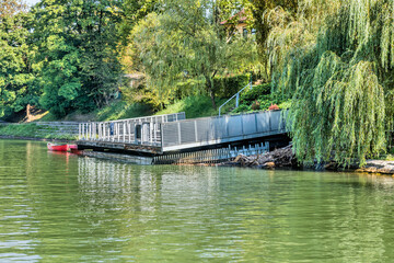 Boat dock with metal railing on calm riverbank.