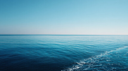Obraz premium Serene ocean with clear horizon and gentle waves under bright blue sky