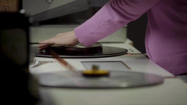 Persona manipulando pel&iacute;cula f&iacute;lmica de 16mm o 35mm en mesa de montaje f&iacute;sico. Montaje, Cine anal&oacute;gico, moviola, edici&oacute;n tradicional, cinematograf&iacute;a, historia del cine.