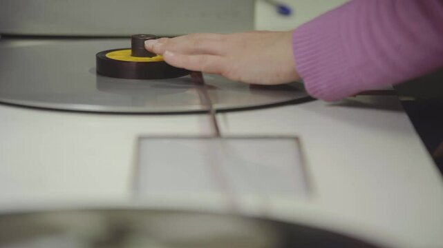 Persona manipulando pel&iacute;cula f&iacute;lmica de 16mm o 35mm en mesa de montaje f&iacute;sico. Montaje, Cine anal&oacute;gico, moviola, edici&oacute;n tradicional, cinematograf&iacute;a, historia del cine.