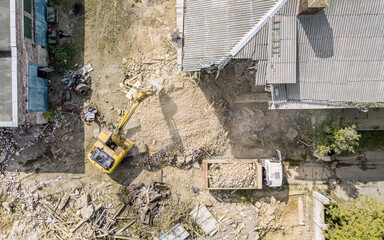 loading by excavator of construction debris of the old building after destruction. drone photo.