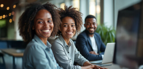 Obraz premium A diverse group of confident professionals smiling in a bright modern office, exuding positivity and tech-savvy collaboration.