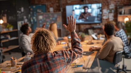 team member raising hand in room while remote attendee reacts on screen