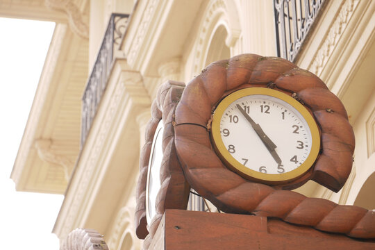 Vintage wooden clock displays time on an architectural building