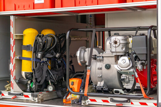Firefighting equipment inside the rescue vehicle – visible oxygen cylinders, breathing apparatus, water pump and other firefighting and rescue equipment. Professional fire brigade equipment ready for 