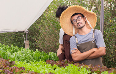 man wear straw hat  standing  with hydroponics vegetables 